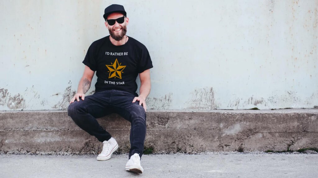 male_sitting_01_social_1920x1080 Man in a baseball cap wearing a black t-shirt